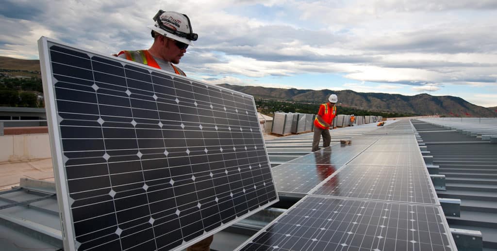 Workers placing solar panels.