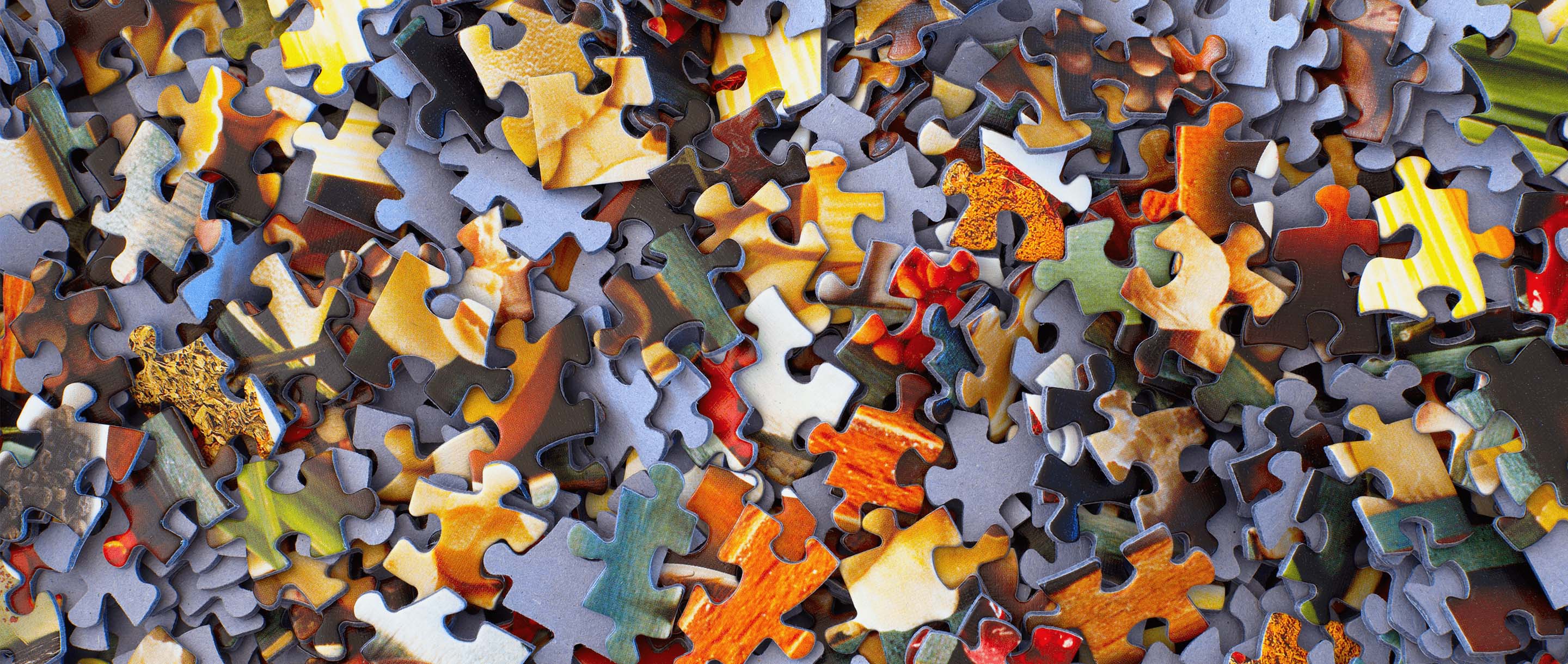 An image showing puzzle pieces all mixed up in a pile.
