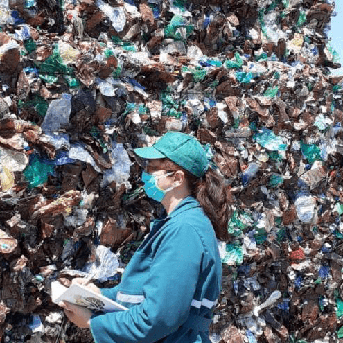 An image of a woman taking notes at a plastic recycling facility.