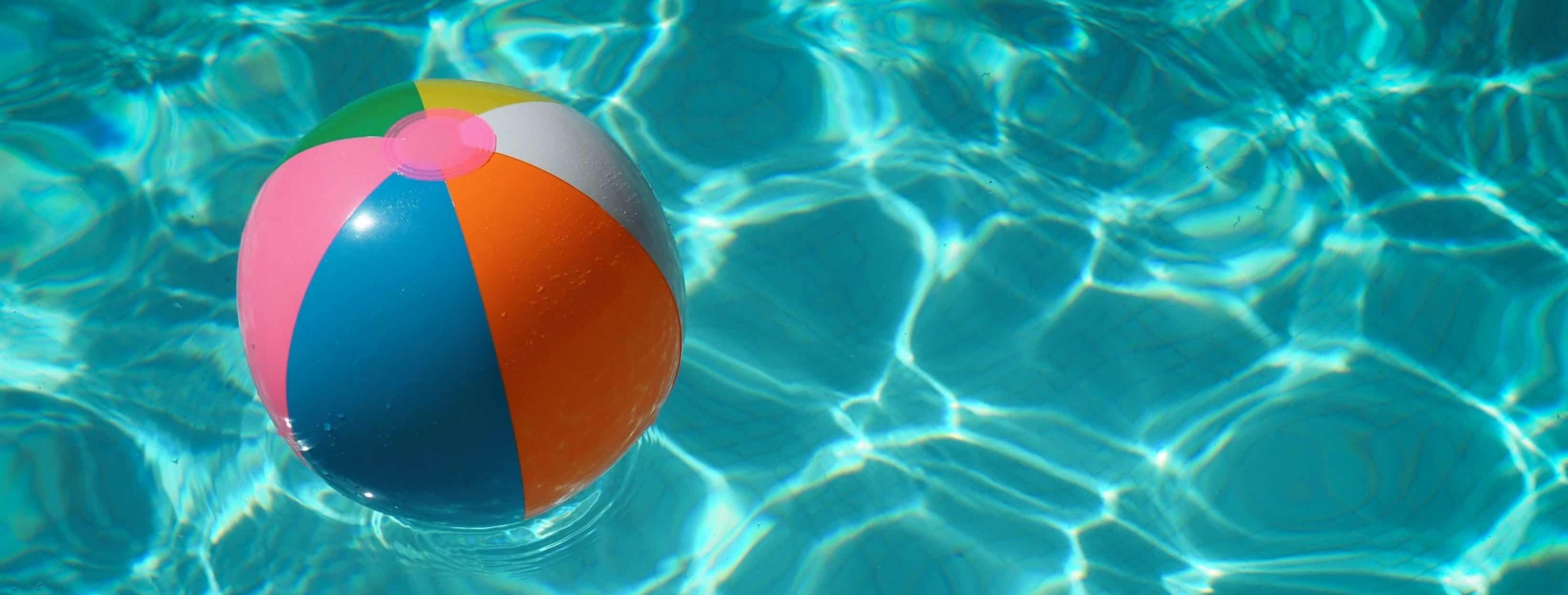 An image of a beach ball floating in pool water.