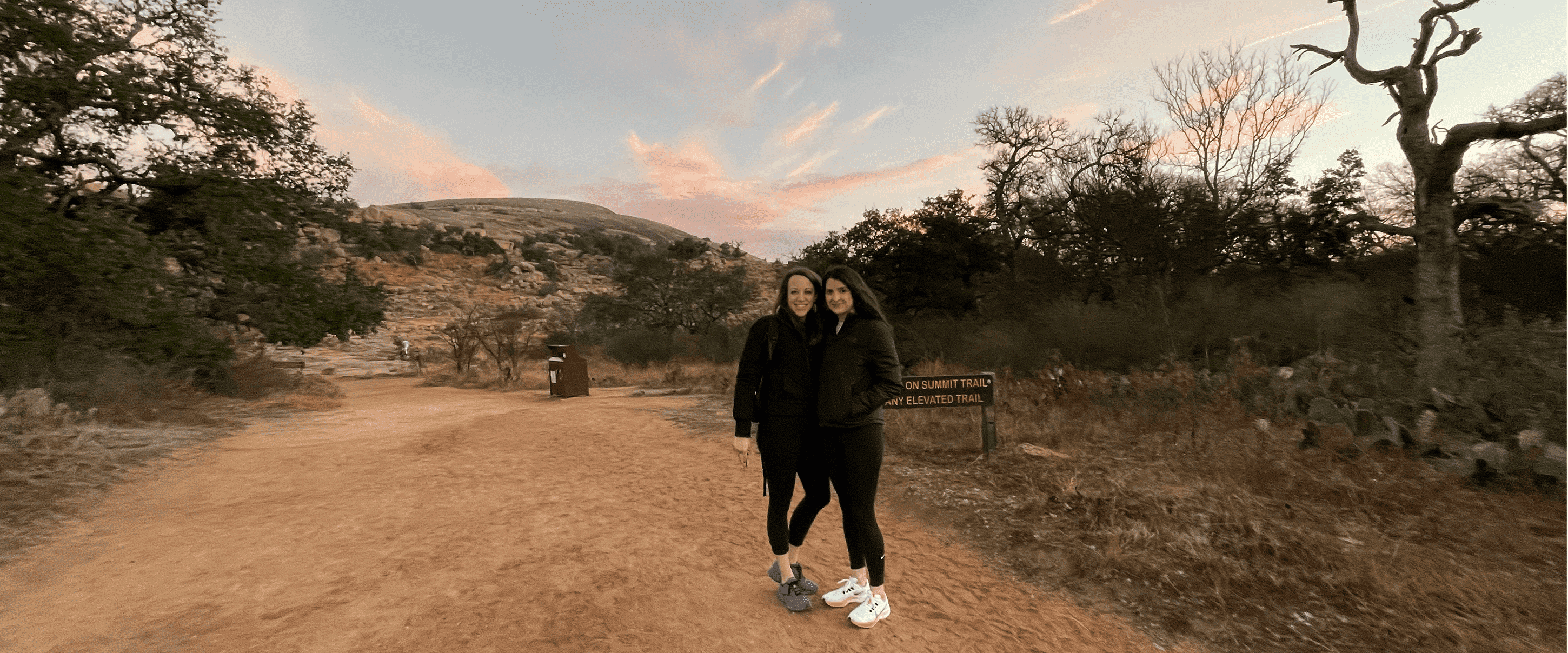Ariana Carruth, Director of Business Development, posing in front of Enchanted Rock, in Texas, with her partner.