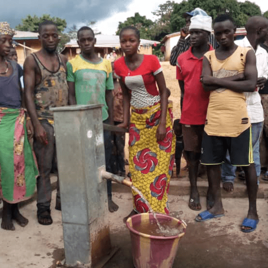 Sierra Leone residents standing around a water pump.