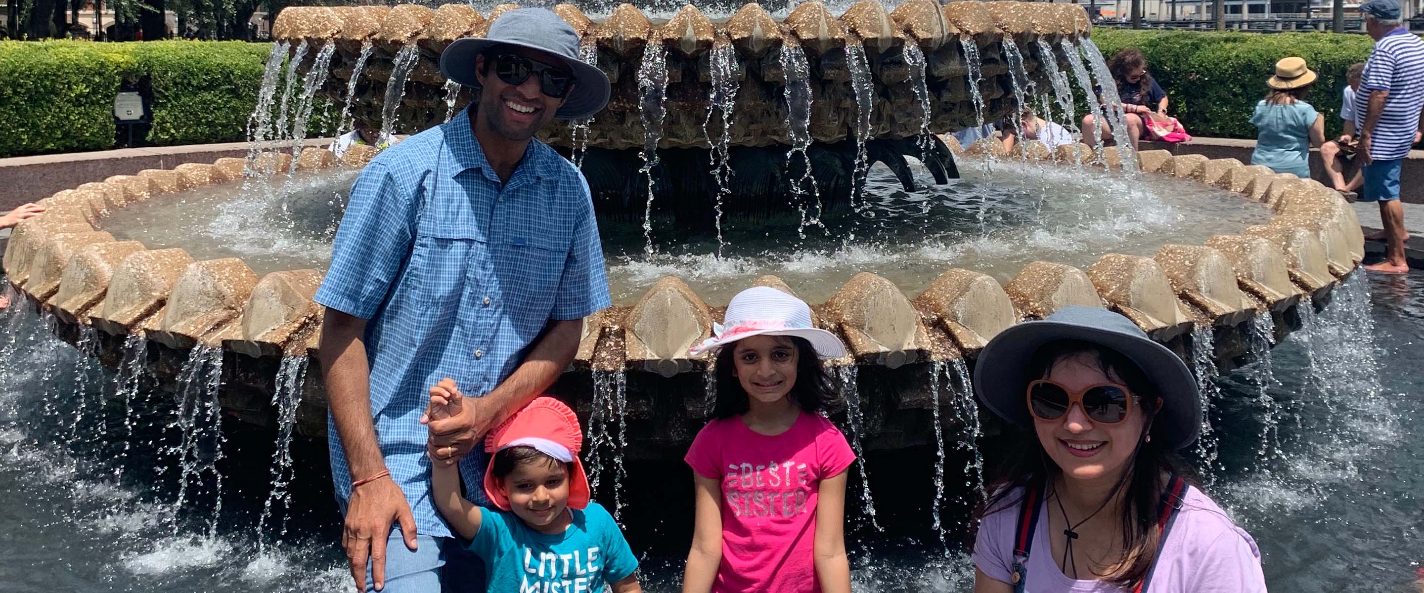 Pankaj Tanwar and family in front of a fountain.